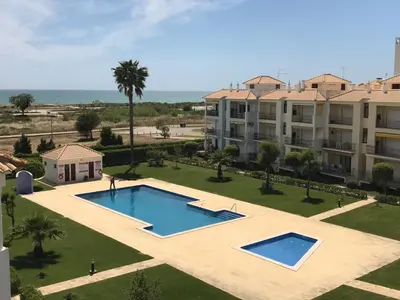 an apartment with a swimming pool in front of a building at Vila Columbus T2 Frente Mar e Piscina in Quarteira
