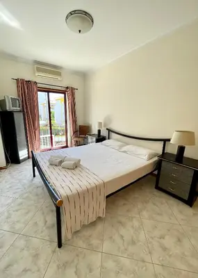 a living room with a glass table and white chairs at Vila Columbus T2 Frente Mar e Piscina in Quarteira