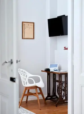 a desk with a white chair and a table with a laptop at Pereiras House of Charm - Downtown in Faro