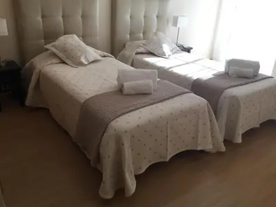 two beds in a room with white sheets at Paradise Beach Villa in Albufeira