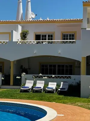 a couple of lounge chairs sitting next to a house at Paradise Beach Villa in Albufeira