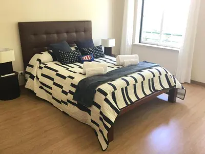 a bedroom with a large bed with a black and white blanket at Paradise Beach Villa in Albufeira