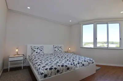 a white bedroom with a bed and a window at Amendoeiras II - Central Vilamoura in Vilamoura