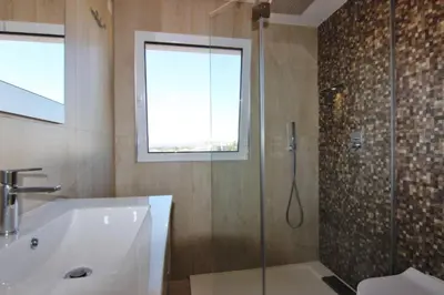 a bathroom with a shower and a tub and a sink at Amendoeiras II - Central Vilamoura in Vilamoura