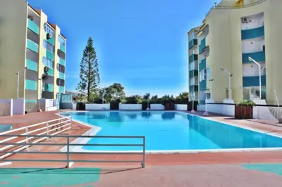 a swimming pool in the courtyard of a apartment building at Amendoeiras II - Central Vilamoura in Vilamoura