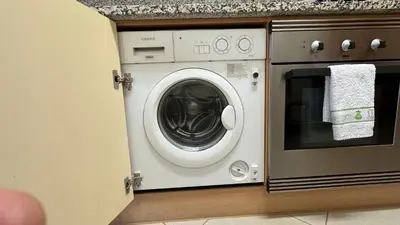 a washing machine in a kitchen next to a oven at Apartamento Costa in Albufeira