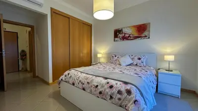 a bedroom with a bed and two lamps in it at Apartamento Costa in Albufeira