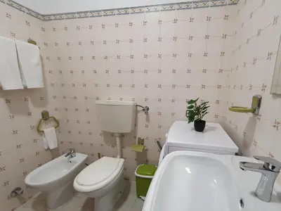 a bathroom with a white toilet and a sink at Solaris- Familiar, Wifi, Totalmente Equipado in Quarteira