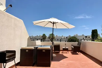 a patio with an umbrella and a table and chairs at Albufeira Jardim l old town and beach - Hawai in Albufeira