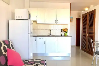 a kitchen with white cabinets and a white refrigerator at Albufeira Jardim l old town and beach - Hawai in Albufeira