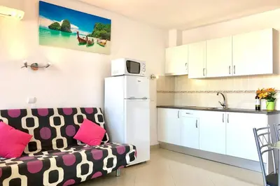 a living room with a couch and a kitchen at Albufeira Jardim l old town and beach - Hawai in Albufeira