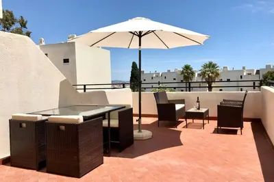 a patio with a table and an umbrella at Albufeira Jardim l old town and beach - Hawai in Albufeira