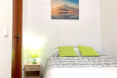 a white bedroom with a bed with green pillows at Albufeira Jardim l old town and beach - Hawai in Albufeira