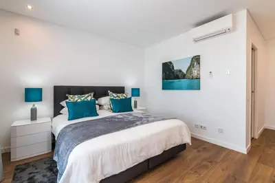 a bedroom with a large bed with blue pillows at Colinas do Golfe Vilamoura Sun by SAPvillas in Vilamoura