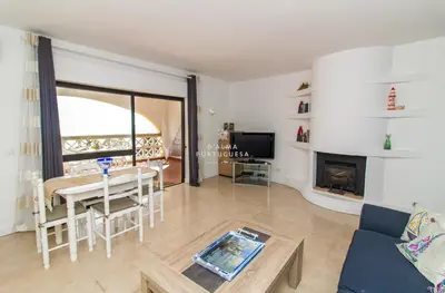 a living room with a table and a fireplace at Apartment Aveiros Beach- D´Alma Amado in Albufeira