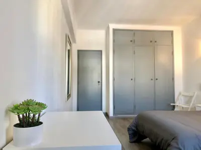 a bedroom with a bed and a table with a potted plant at Albufeira I old town and city center in Albufeira