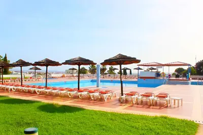 a row of chairs and umbrellas next to a pool at Cozy and Stylish Studio Apt - just 800m from the beach in Albufeira