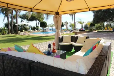 a patio with a couch and chairs under an umbrella at Elegant Villa in Loulé with Private Pool in Loulé