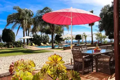a patio with a table with a red umbrella at Elegant Villa in Loulé with Private Pool in Loulé