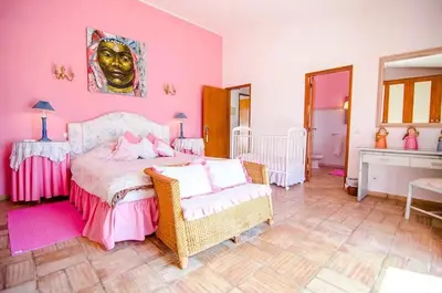 a bedroom with pink walls and a bed and chairs at Elegant Villa in Loulé with Private Pool in Loulé