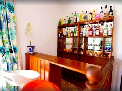 a bar with a shelf filled with lots of alcohol at Elegant villa with sea view in Loulé + private pool in Loulé