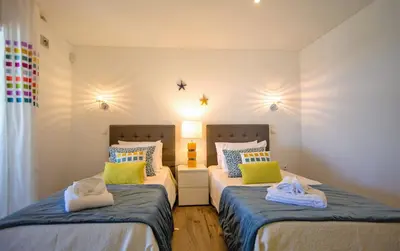 a bedroom with a bed and a large window at Villa Front de Mer avec Piscine Jacuzzi Accès Privé Plage en famille et entre amis in Albufeira