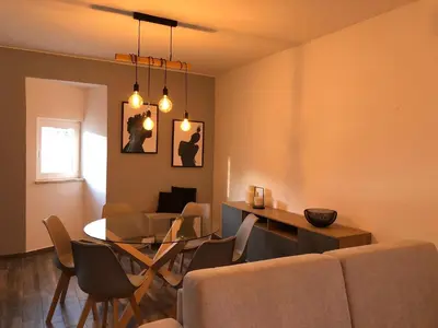 a living room with a couch and a table and chairs at Albufeira Emblematica Apartment - Wifi & Pool in Albufeira