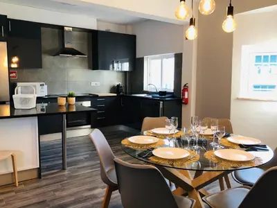 a kitchen and dining room with a table and chairs at Albufeira Emblematica Apartment - Wifi & Pool in Albufeira