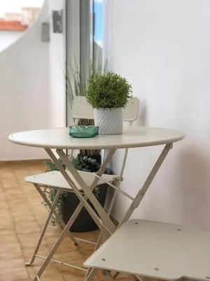 a table with a potted plant and two chairs at Albufeira Emblematica Apartment - Wifi & Pool in Albufeira