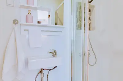 a white bathroom with a sink and a shower at Groundfloor in Faro