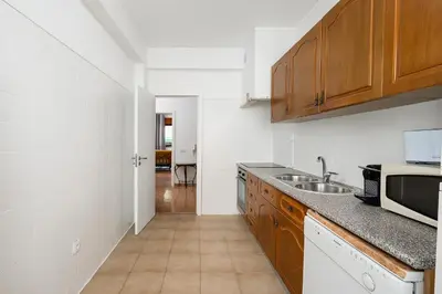 a kitchen with wooden cabinets and a sink at Casa Bela in Faro