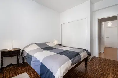 a bedroom with a bed and a table with a lamp at Casa Bela in Faro
