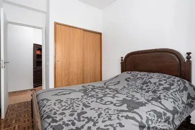 a bedroom with a bed with a black and white comforter at Casa Bela in Faro