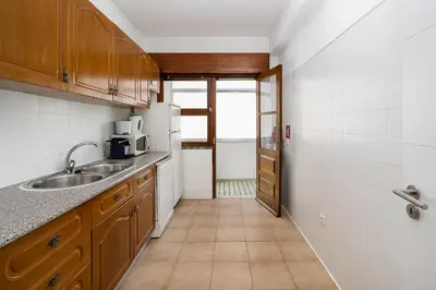 a small kitchen with a sink and a microwave at Casa Bela in Faro