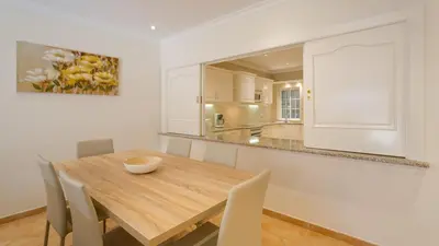 a kitchen and dining room with a wooden table and chairs at Joanne in Vale do Lobo