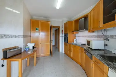 a kitchen with wooden cabinets and a counter top at AL - Maré in Albufeira