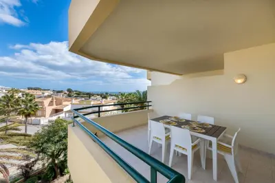 a balcony with a table and chairs and a view of the city at AL - Maré in Albufeira