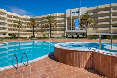 a swimming pool in front of a building at AL - Maré in Albufeira