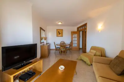 a living room with a couch and a tv at AL - Maré in Albufeira