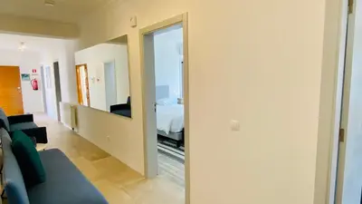 a hallway with a mirror and a room with a bed at Otto by Check-in Portugal in Quarteira