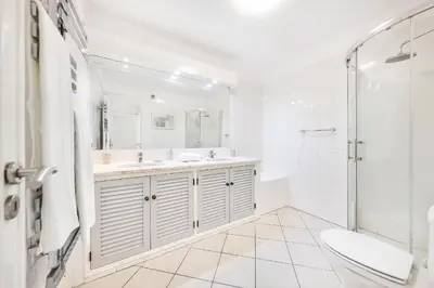 a white bathroom with a sink and a shower at Apartament Portes Balaia Golf Resort in Albufeira