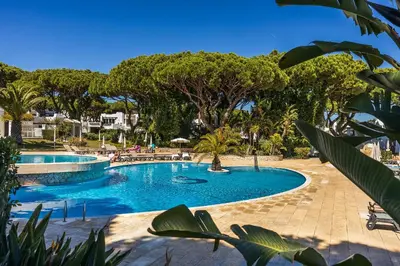 a swimming pool in a resort with trees at Apartament Portes Balaia Golf Resort in Albufeira