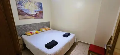 a bedroom with a bed with a painting on the wall at Open Space - Albufeira in Albufeira