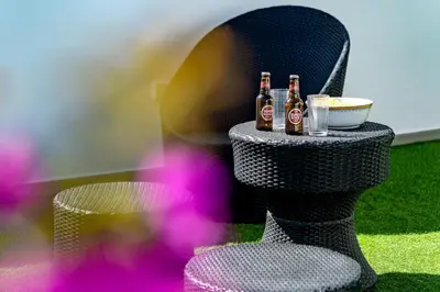 three bottles of beer sitting on a chair with a bowl of food at Casa Maya - Vale do Garrão in Quinta do Lago
