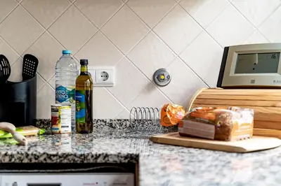 a kitchen counter with a cutting board and a bottle of wine at Casa Maya - Vale do Garrão in Quinta do Lago