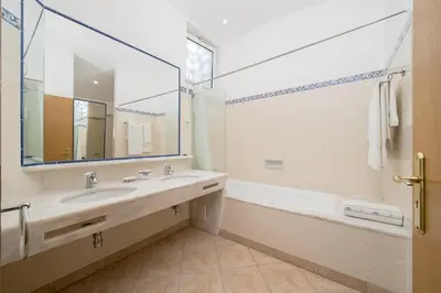a bathroom with a sink and a tub and a mirror at Casa Maya - Vale do Garrão in Quinta do Lago