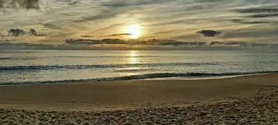 a sunset over the ocean with a sandy beach at Casa Senhora da Ria- localização perfeita em Faro in Faro