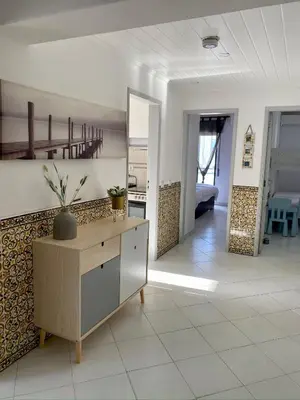 a living room with a table and a mirror at CosyAvenida Mar, 2 rooms in Quarteira