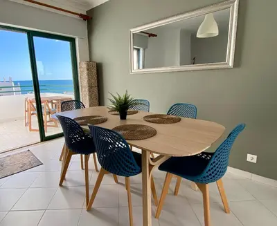 a dining room with a table and chairs and a mirror at CosyAvenida Mar, 2 rooms in Quarteira