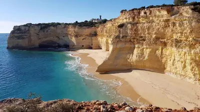 a cliff with a beach and the ocean at Cozy Garden T1 near the beach in Albufeira